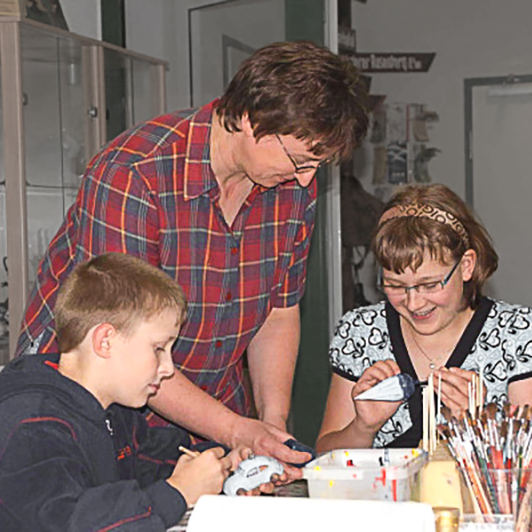 Children painting christmas ornaments | Glavena Glavena owner and children painting christmas ornaments